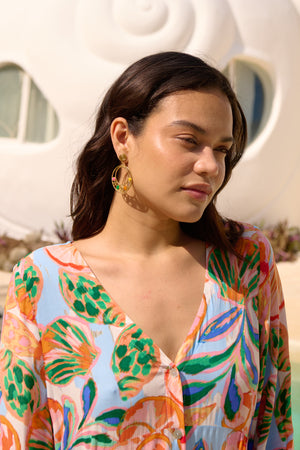 Woman wearing a colorful patterned dress with a blurred background