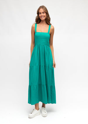 Woman wearing a teal dress on a white background