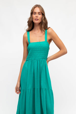 Woman wearing a teal dress on a white background