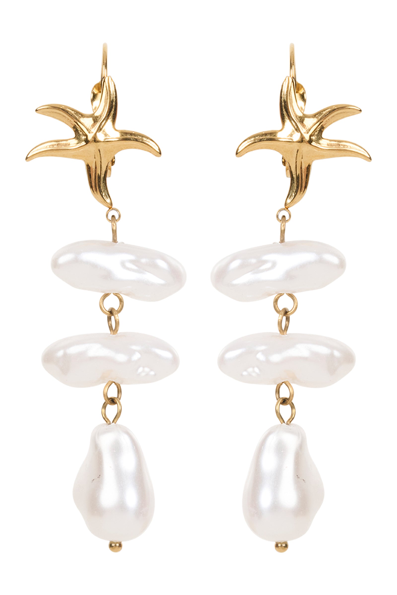 Woman with curly blonde hair wearing a colorful floral dress against a white background